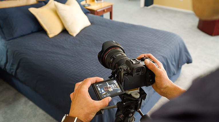 Person taking pictures of bedroom