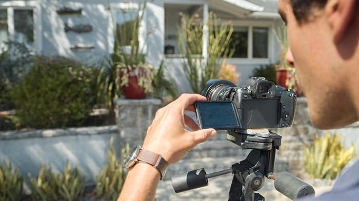 Person taking exterior photos with a camera on a tripod