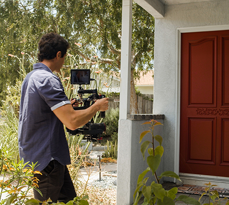 Man approaching door holding camera rig