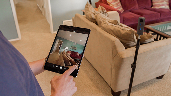 Person using tablet to take 360 degree photograph of a living room